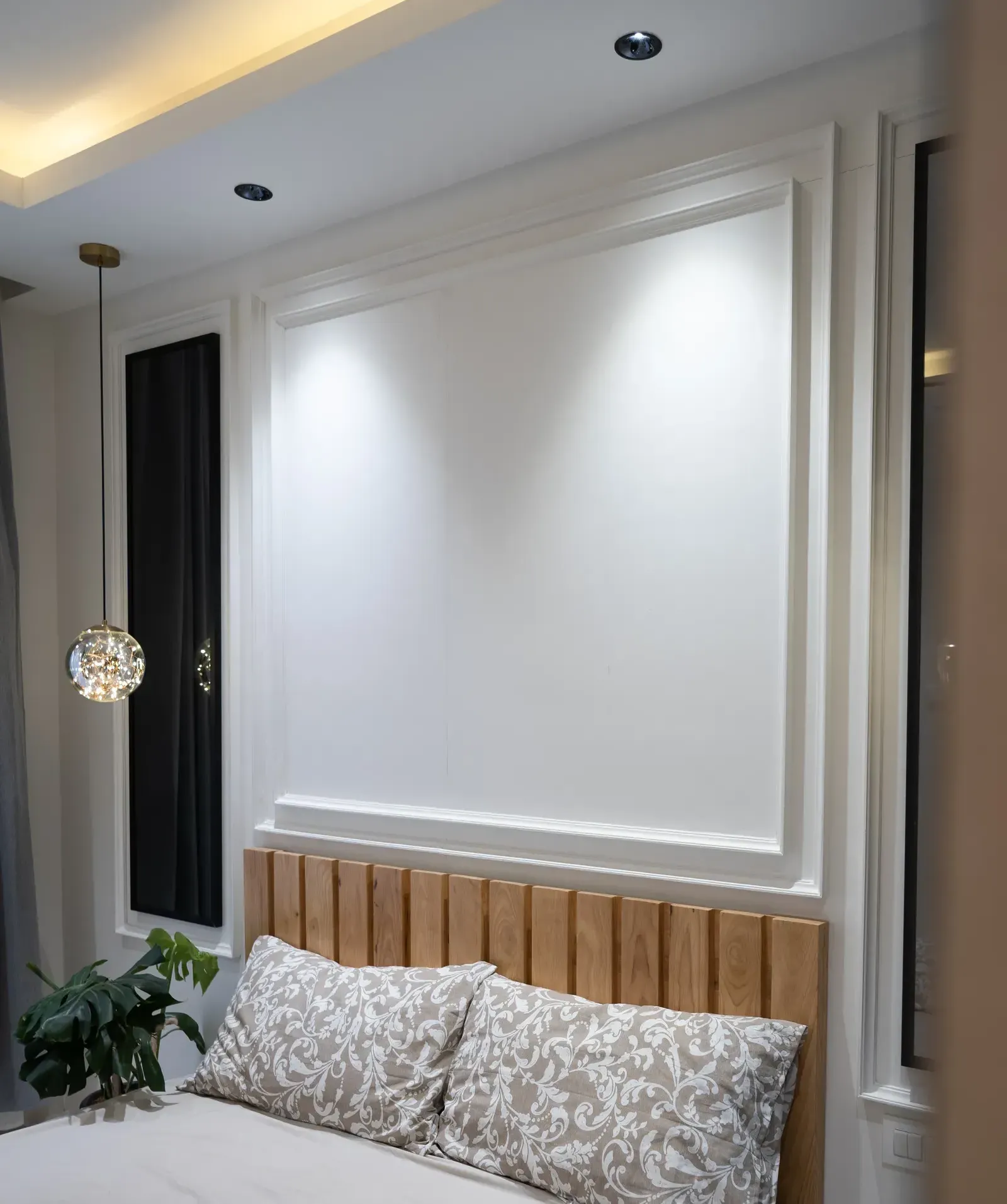 White panelled wall above an oak-slat headboard — The Aakar